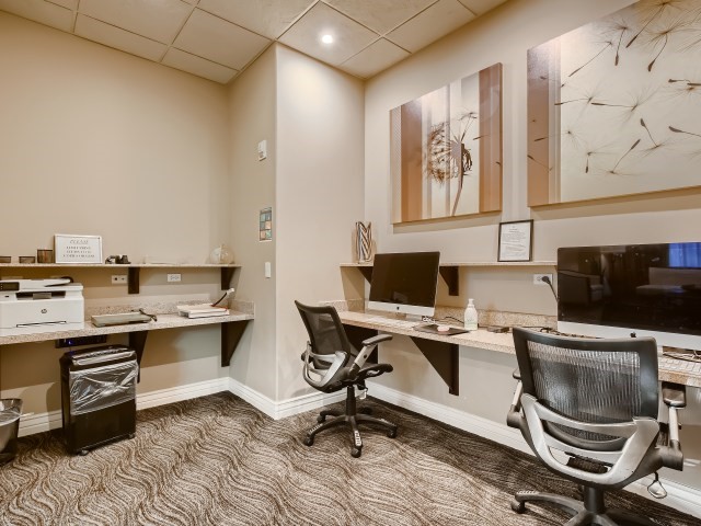 carpeted office featuring a drop ceiling and built in desk