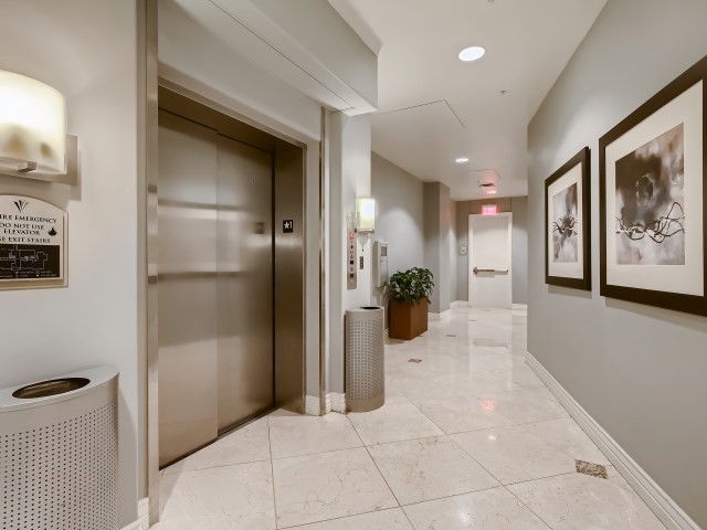 hallway featuring elevator and light tile floors