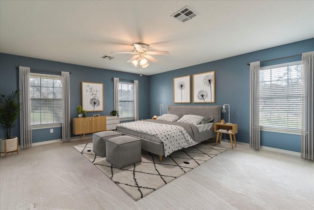 carpeted bedroom featuring ceiling fan and multiple windows