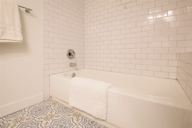 bathroom with tiled shower / bath combo and tile patterned flooring