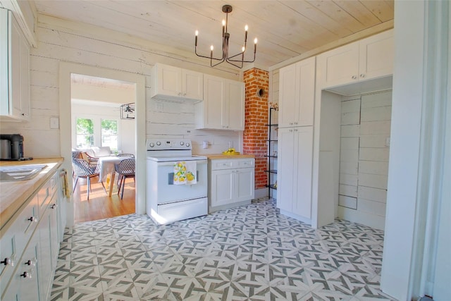 kitchen with wood walls, white range with electric cooktop, hanging light fixtures, white cabinetry, and wooden ceiling