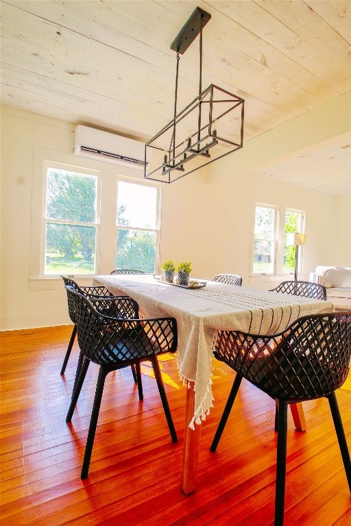 dining space with plenty of natural light, a wall unit AC, and hardwood / wood-style floors