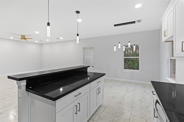 kitchen with white cabinets, ceiling fan, a center island, and hanging light fixtures