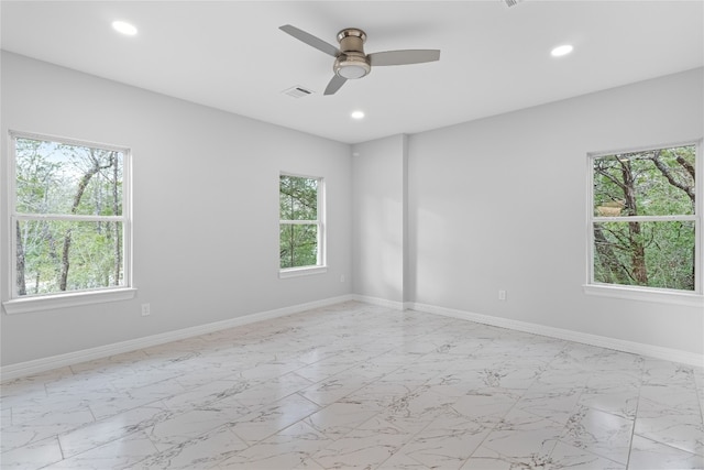 spare room with ceiling fan and a wealth of natural light