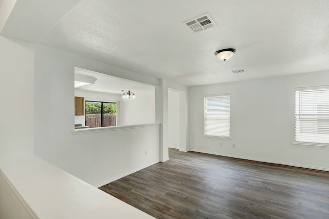 unfurnished room with dark wood-type flooring and a textured ceiling