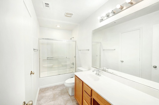 full bathroom featuring tile floors, toilet, large vanity, and bath / shower combo with glass door