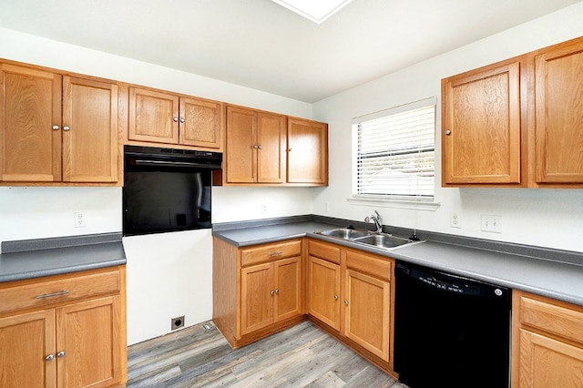 kitchen with light hardwood / wood-style flooring, black appliances, and sink