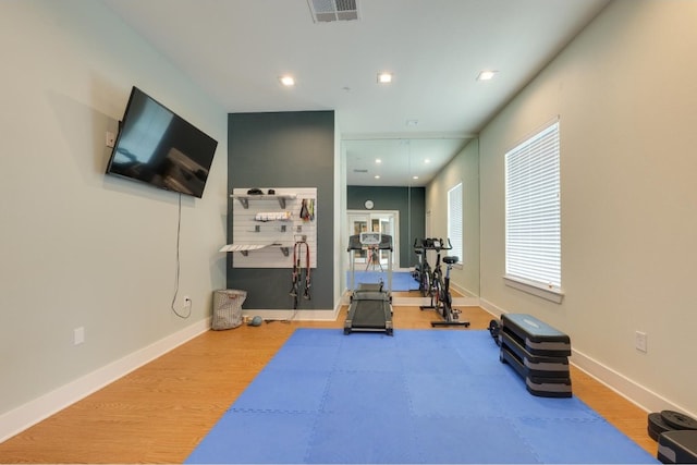 exercise room with light wood-type flooring