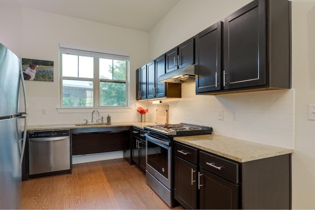 kitchen with sink, light hardwood / wood-style flooring, stainless steel appliances, and tasteful backsplash