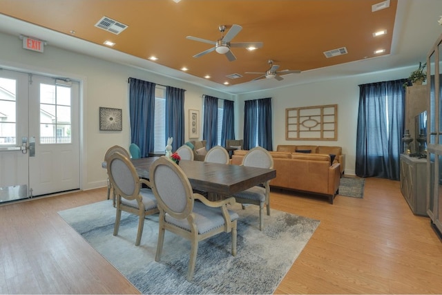 dining space featuring light wood-type flooring, ceiling fan, and french doors