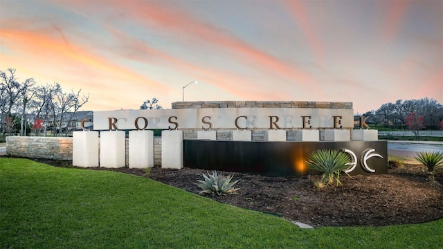 community / neighborhood sign with a lawn