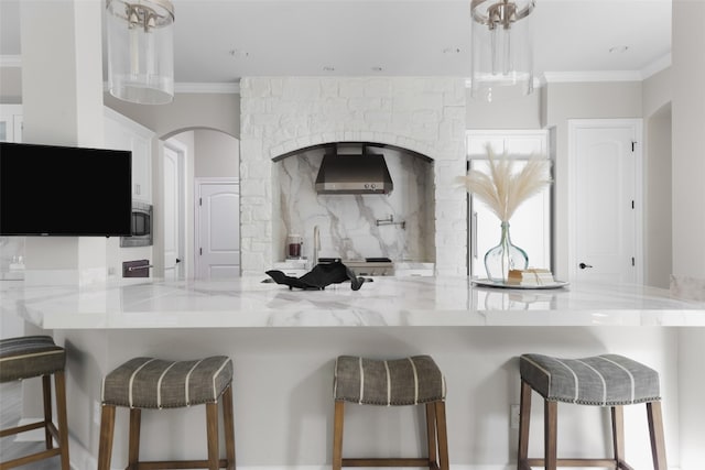 kitchen with a breakfast bar area, kitchen peninsula, and white cabinetry