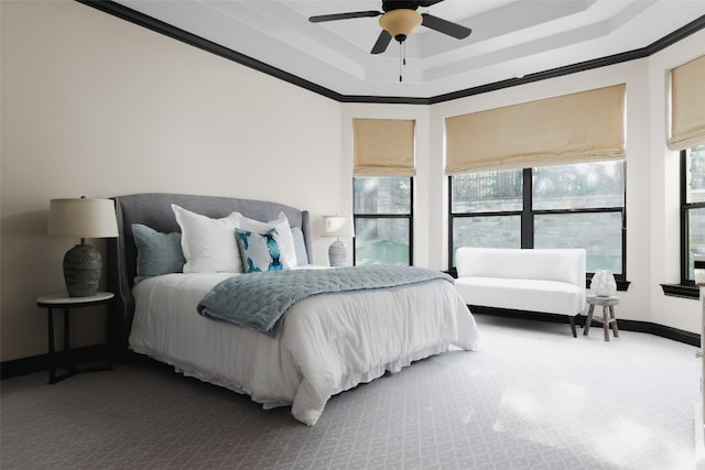 bedroom featuring ceiling fan, carpet floors, crown molding, and a tray ceiling