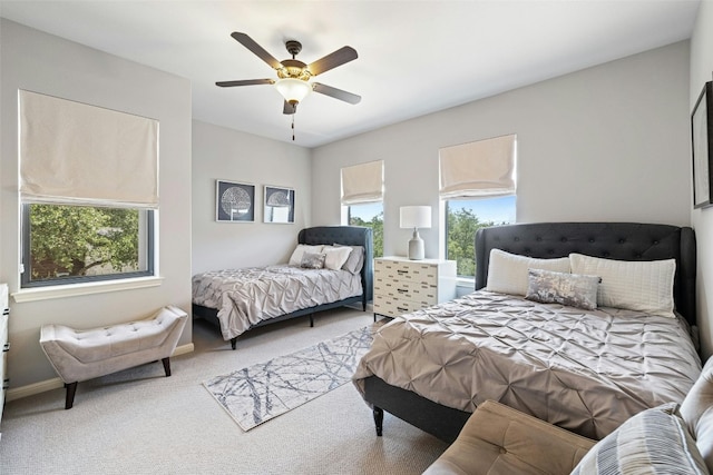 carpeted bedroom featuring multiple windows and ceiling fan