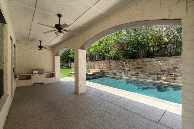 view of pool featuring grilling area, ceiling fan, exterior kitchen, and a patio