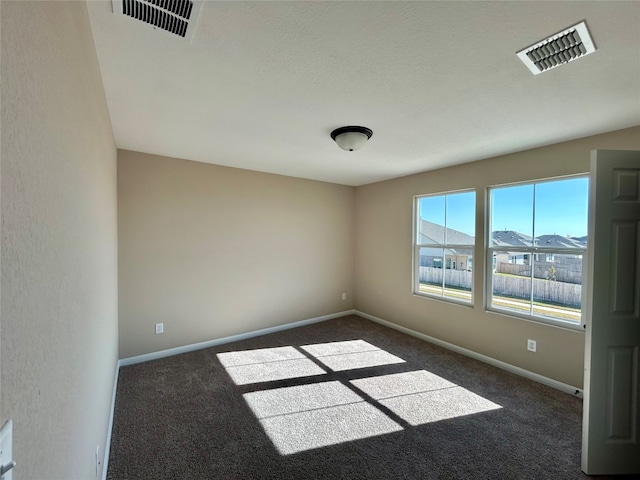 empty room with dark colored carpet