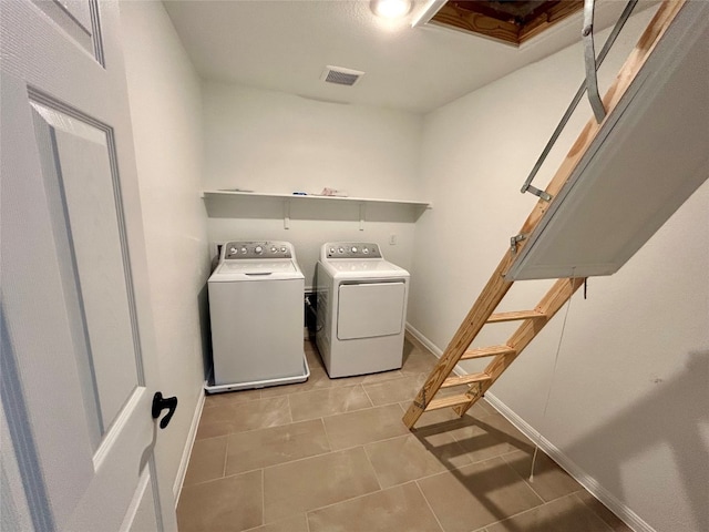 clothes washing area featuring light tile patterned floors and separate washer and dryer