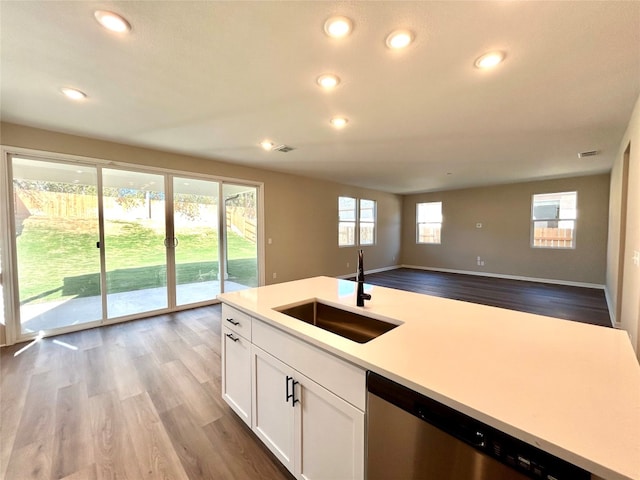 kitchen featuring sink, dishwasher, light wood-type flooring, and white cabinets