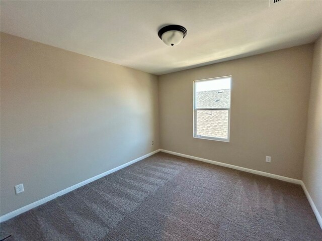 unfurnished room with dark carpet