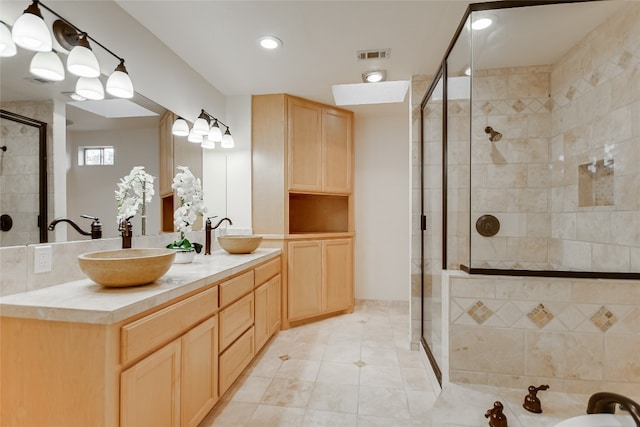 bathroom featuring tile patterned floors, an enclosed shower, and vanity