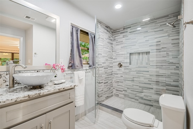 bathroom featuring plenty of natural light, toilet, an enclosed shower, and vanity