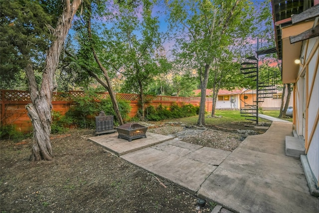 yard at dusk featuring an outdoor fire pit and a patio area