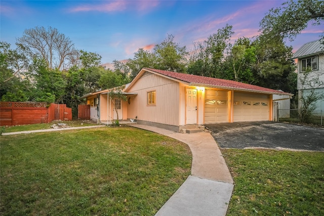 view of front of property with a garage and a lawn