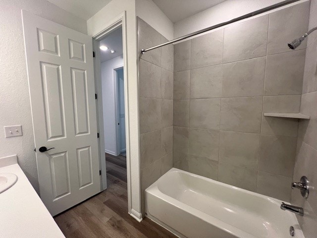 bathroom featuring tiled shower / bath combo, vanity, and hardwood / wood-style floors