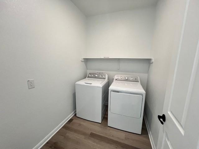 laundry area featuring laundry area, baseboards, wood finished floors, and independent washer and dryer