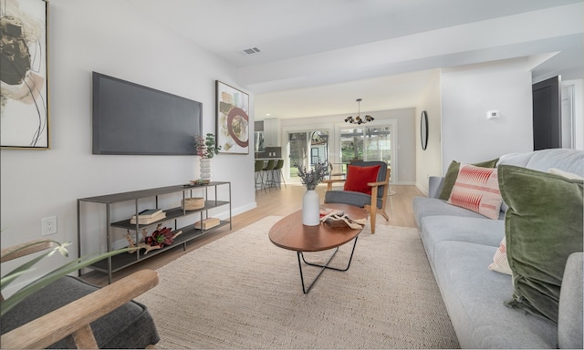 living room with an inviting chandelier and wood-type flooring