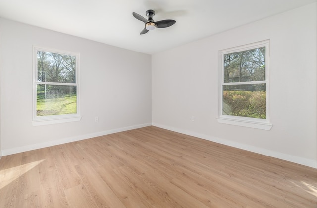 spare room with plenty of natural light, light wood-type flooring, and ceiling fan