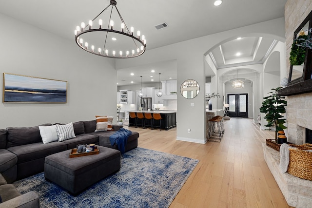 living room featuring french doors, light hardwood / wood-style flooring, and a fireplace