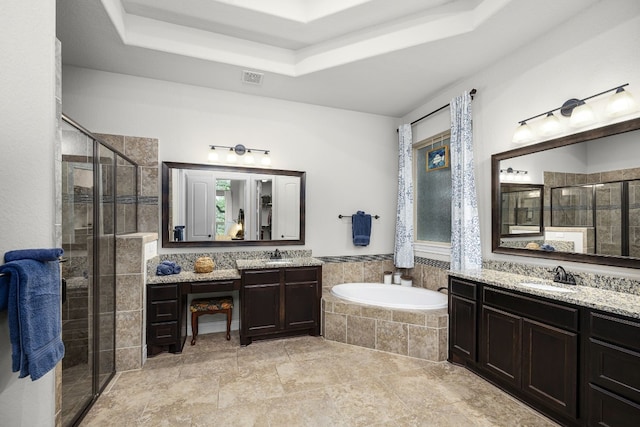 bathroom with vanity, a raised ceiling, and shower with separate bathtub