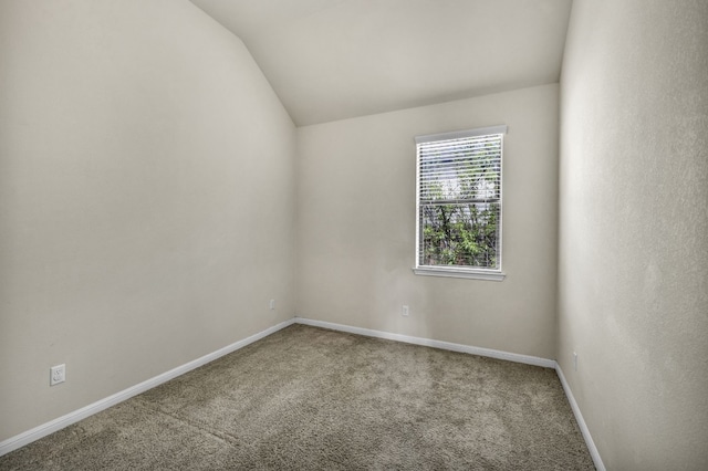 carpeted spare room featuring lofted ceiling