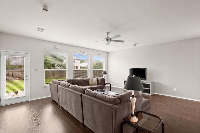 living room featuring ceiling fan and dark wood-type flooring