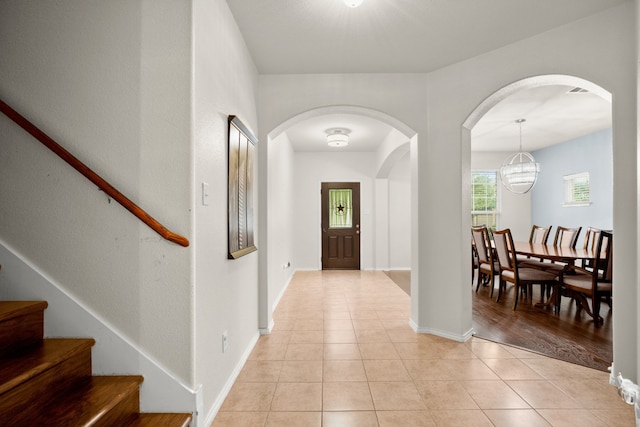 entryway with light hardwood / wood-style floors and a chandelier