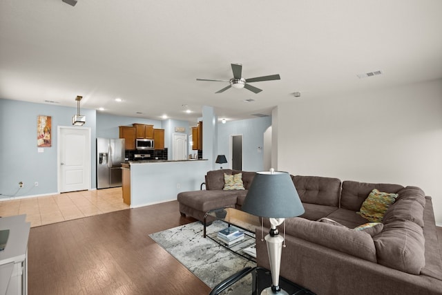 living room with light hardwood / wood-style floors and ceiling fan