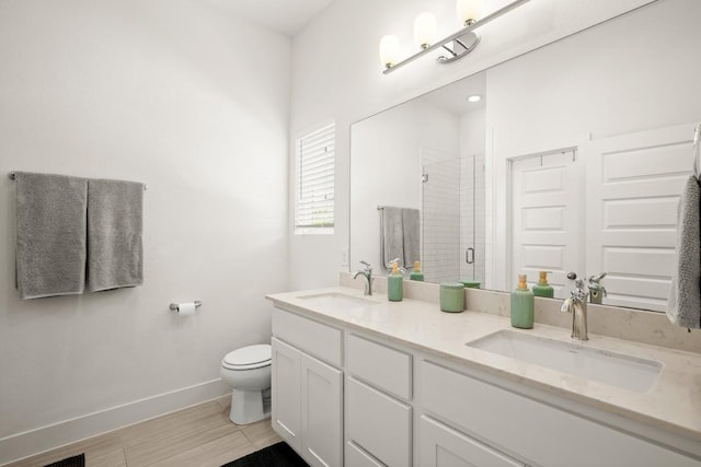 bathroom with vanity, a shower with door, and toilet