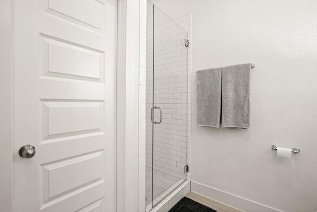 bathroom featuring a shower with shower door