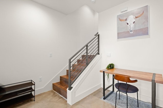 staircase featuring concrete floors