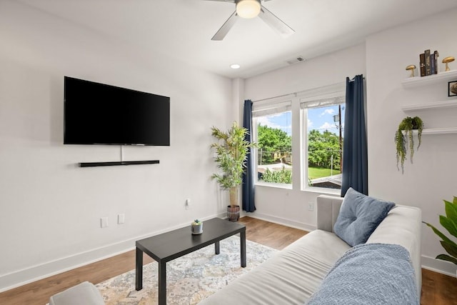 living room with hardwood / wood-style flooring and ceiling fan