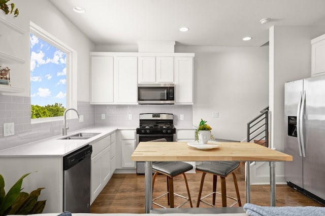 kitchen featuring sink, appliances with stainless steel finishes, white cabinetry, backsplash, and dark hardwood / wood-style flooring