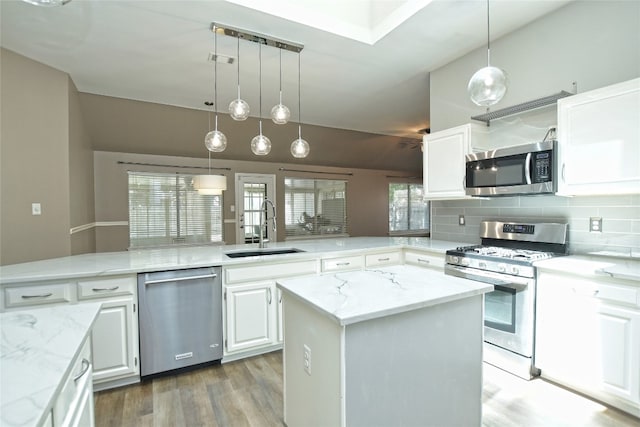 kitchen featuring a kitchen island, kitchen peninsula, appliances with stainless steel finishes, and sink