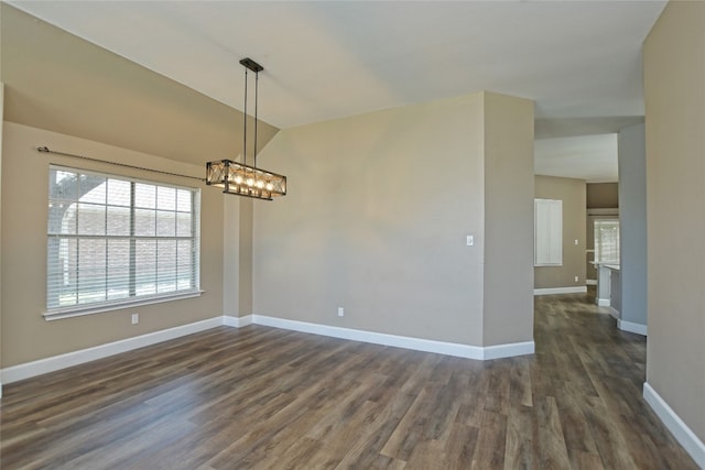 spare room featuring lofted ceiling, a notable chandelier, and dark hardwood / wood-style floors