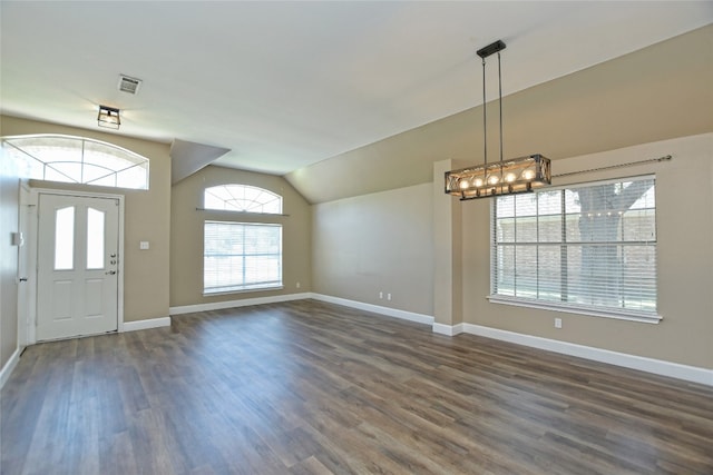 entrance foyer with dark hardwood / wood-style floors, a chandelier, and vaulted ceiling