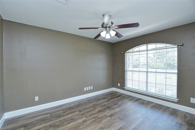 empty room with dark wood-type flooring and ceiling fan