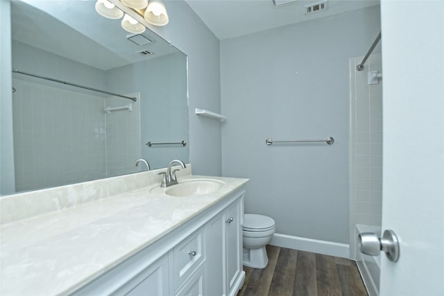 bathroom with toilet, vanity, and hardwood / wood-style flooring