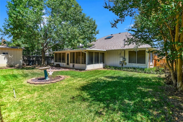 rear view of property featuring a sunroom and a yard