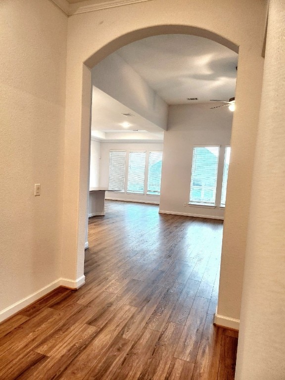 hallway with dark hardwood / wood-style flooring and crown molding