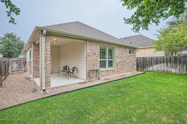 back of property featuring a patio area and a yard